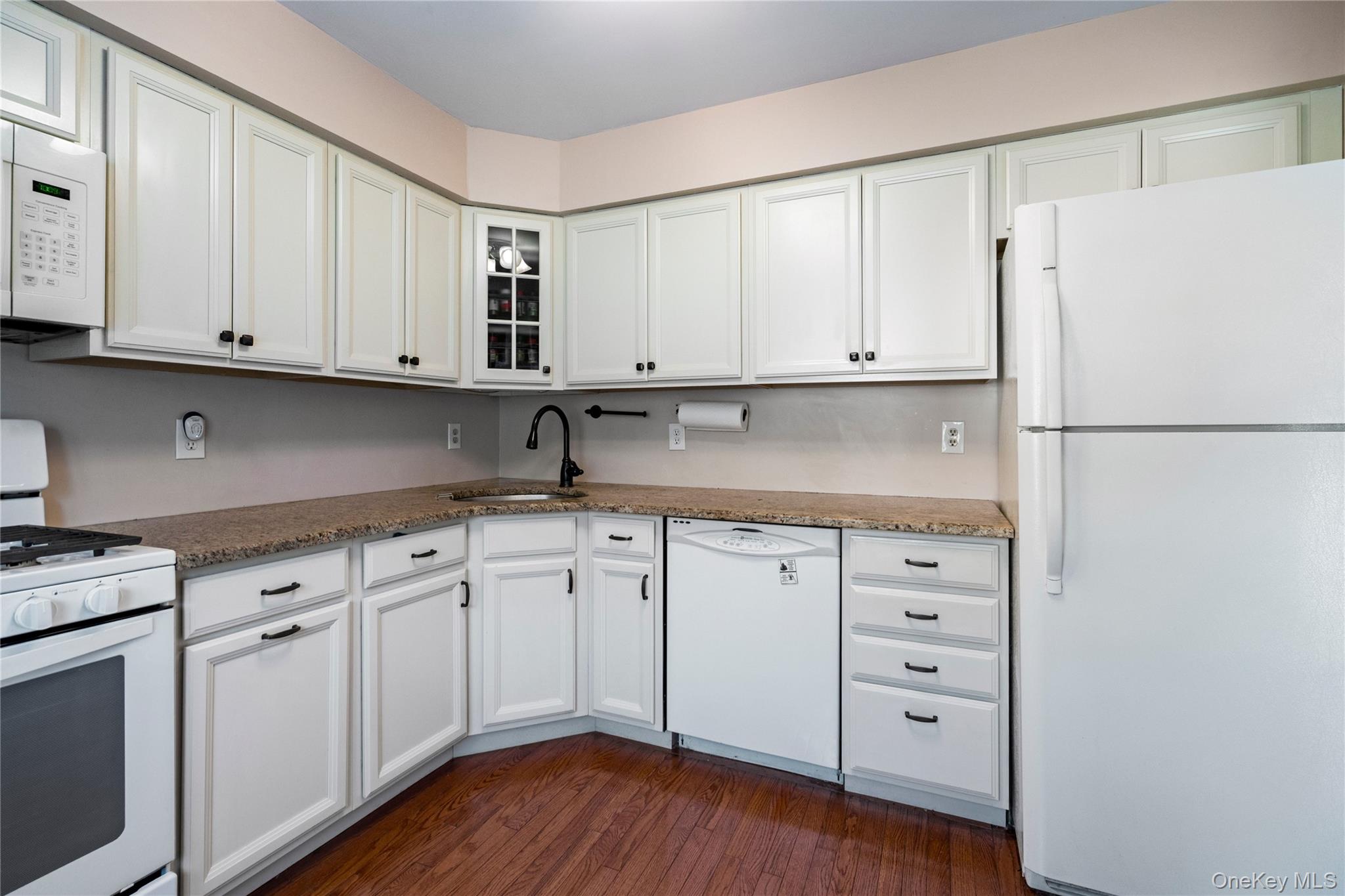 7 Maple Court, Unit 7 Selden, NY 11784 - Photo 6 of 18 a kitchen with granite countertop white cabinets and refrigerator