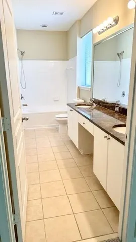 a bathroom with a granite countertop sink a mirror and bathtub