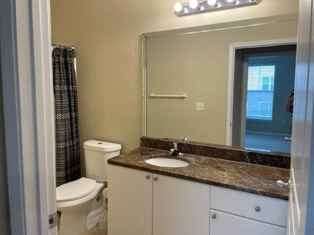 10 Perimeter Summit Boulevard, Unit 1310 Atlanta, GA 30319 - Photo 18 of 24 a bathroom with a granite countertop toilet sink and mirror