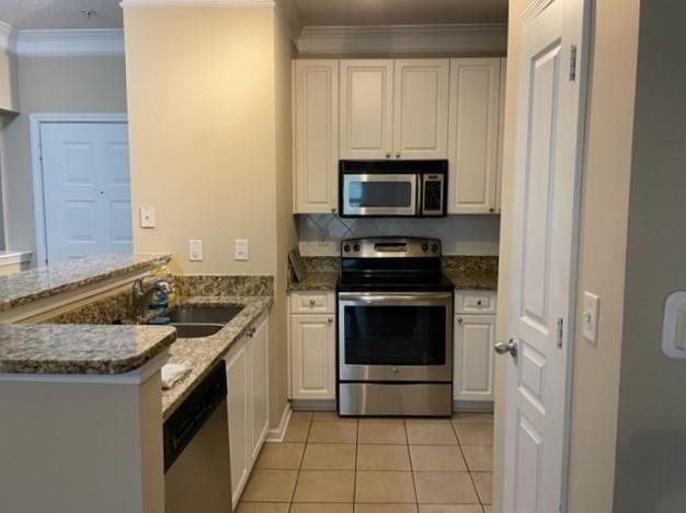 10 Perimeter Summit Boulevard, Unit 1310 Atlanta, GA 30319 - Photo 2 of 24 a kitchen with granite countertop a stove sink and microwave