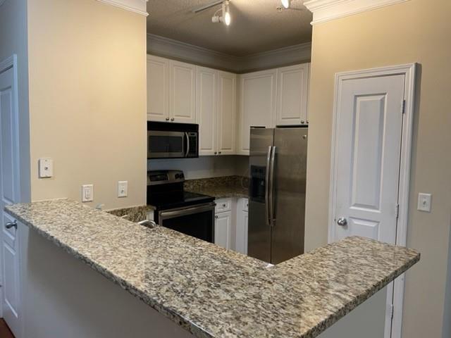 10 Perimeter Summit Boulevard, Unit 1310 Atlanta, GA 30319 - Photo 3 of 24 a kitchen with kitchen island granite countertop a refrigerator and stove