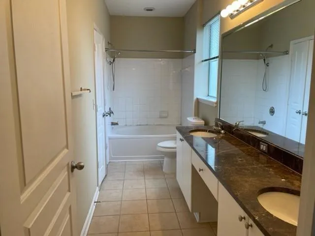 a spacious bathroom with a granite countertop sink a toilet and shower