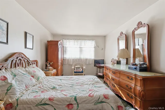 a bedroom with a bed and a mirror on dresser