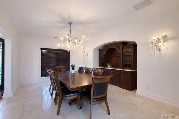 a dining room with furniture a chandelier and window