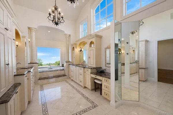 a large white kitchen with stainless steel appliances a stove a refrigerator and a cabinets