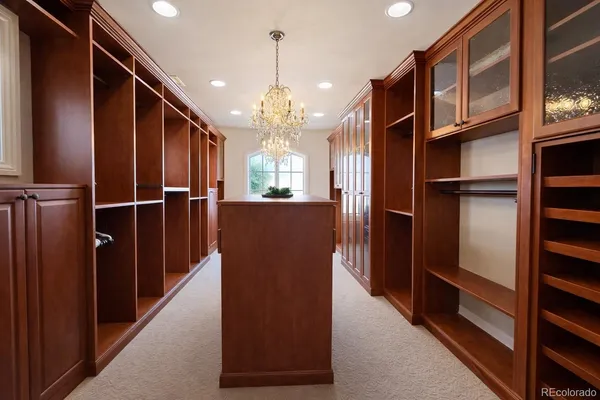a view of a refrigerator in kitchen and an empty room with wooden floor