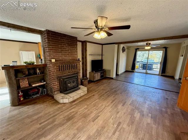 a view of a livingroom with furniture hardwood floor and a ceiling fan