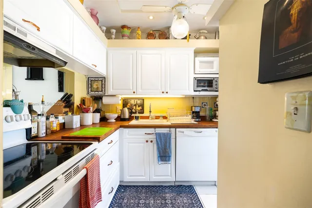 a kitchen with stainless steel appliances granite countertop a sink and a white cabinets