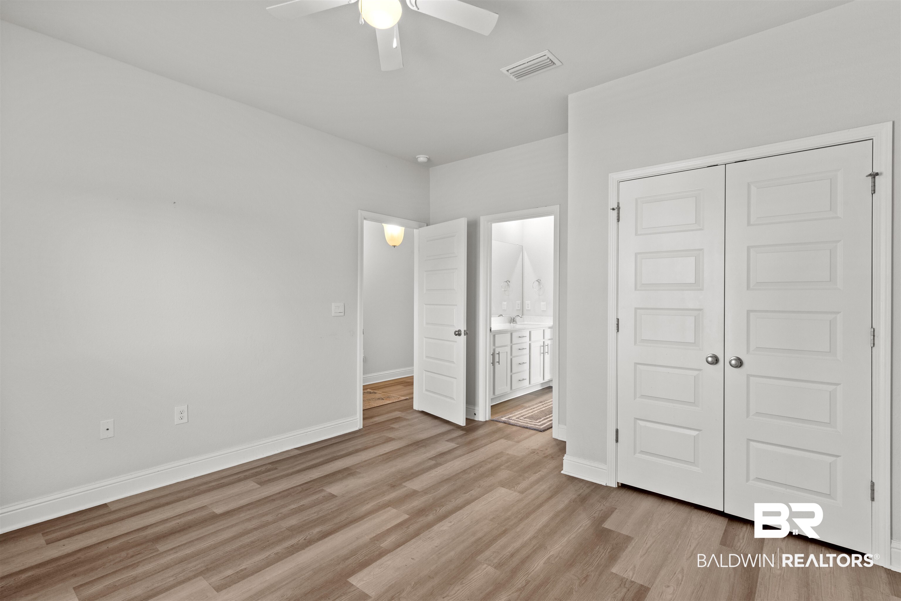 485 Shepard Street Gulf Shores, AL 36542 - Photo 32 of 53 Spare bedroom featuring a closet, ensuite bath, light wood-style floors, and a ceiling fan