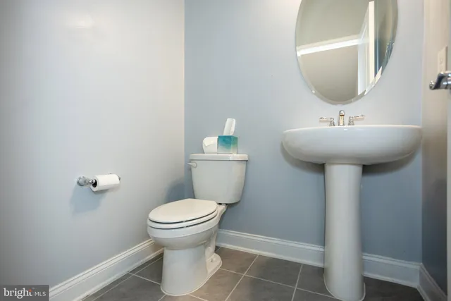 a bathroom with a double vanity sink a toilet a mirror and shower