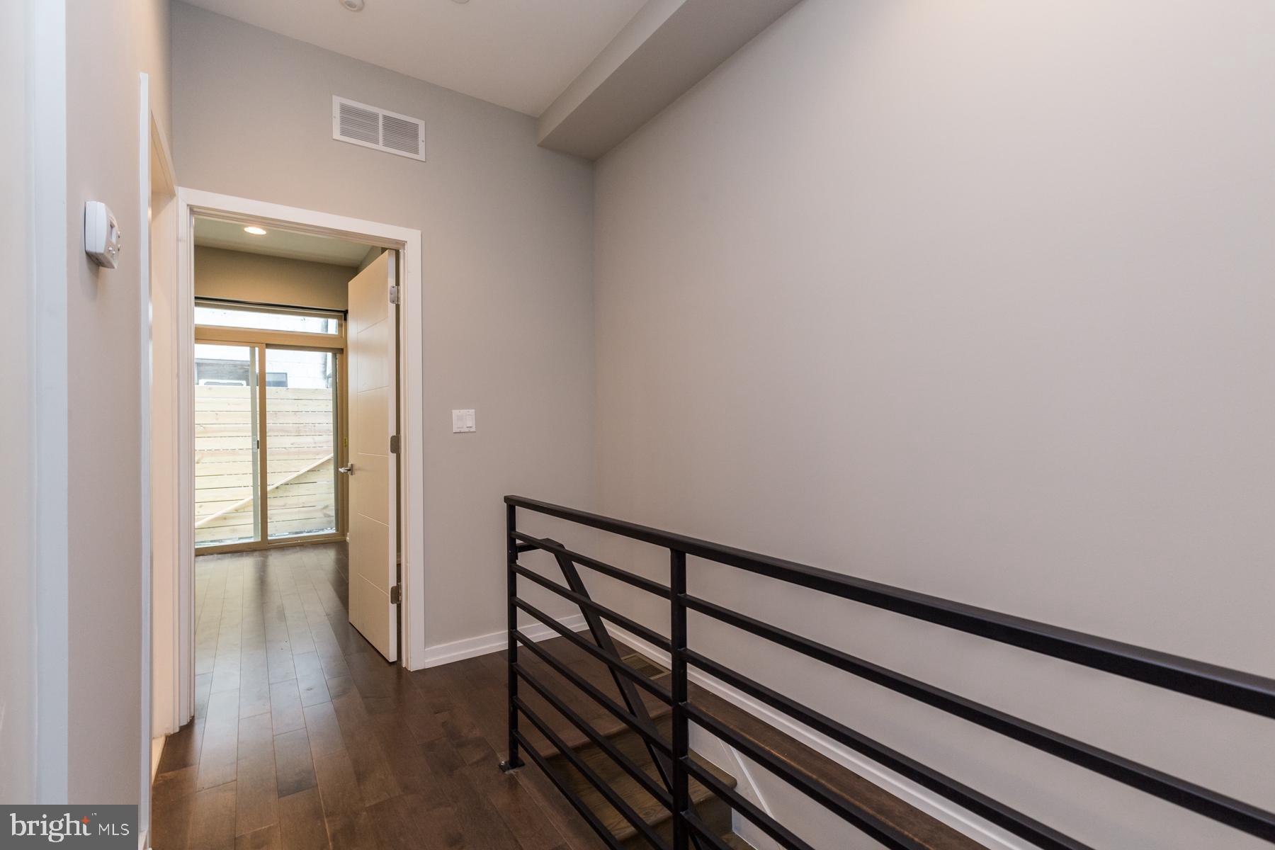 1815 Ranstead Street, Unit 1 Philadelphia, PA 19103 - Photo 7 of 27 a view of a hallway with wooden floor and a bathroom
