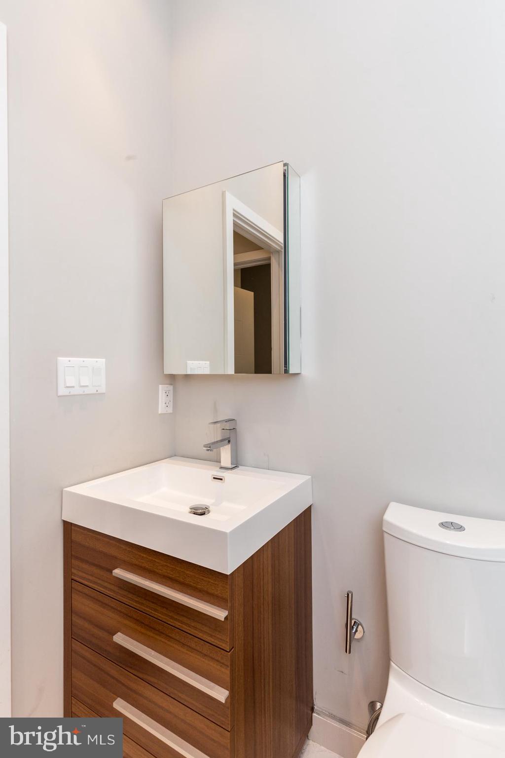 1815 Ranstead Street, Unit 1 Philadelphia, PA 19103 - Photo 9 of 27 a bathroom with a toilet sink and mirror