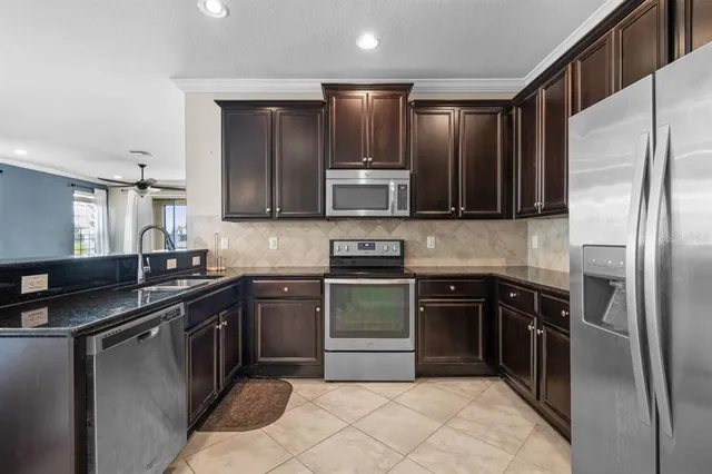 a kitchen with stainless steel appliances granite countertop a refrigerator stove and sink