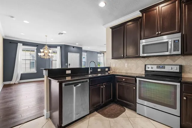 a kitchen with stainless steel appliances granite countertop a stove microwave and sink