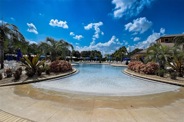 a view of a house with pool and chairs