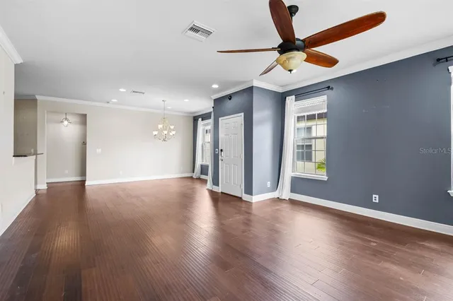 a view of an empty room with window and wooden floor