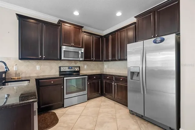a kitchen with stainless steel appliances granite countertop a refrigerator stove and cabinets