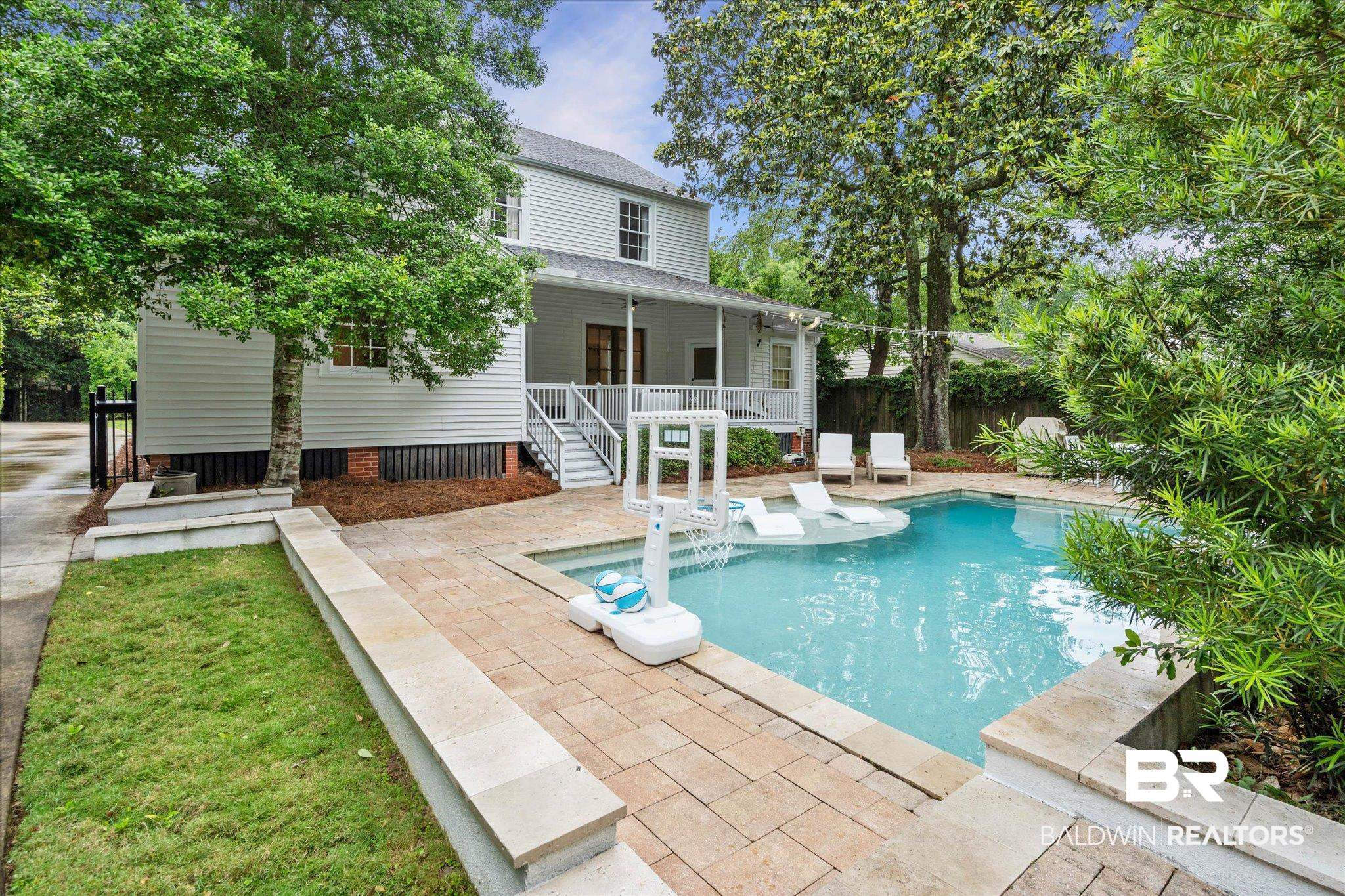 3863 Old Shell Road Mobile, AL 36608 - Photo 34 of 48 Backyard featuring a rectangular pool with a sun shelf, paver patio, surrounding landscaping, and a covered porch