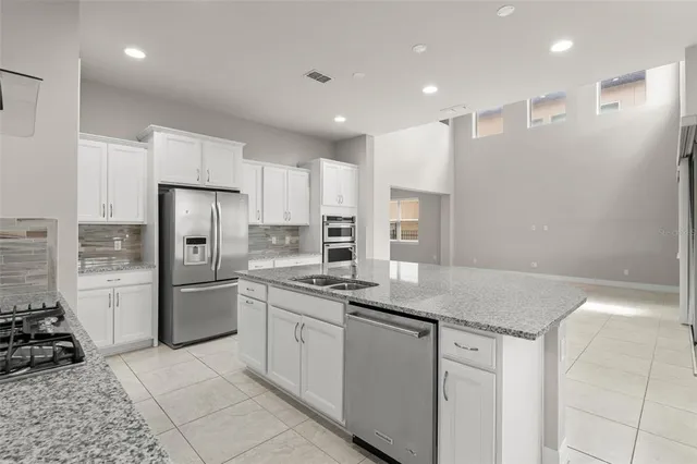 a kitchen with a refrigerator sink and cabinets