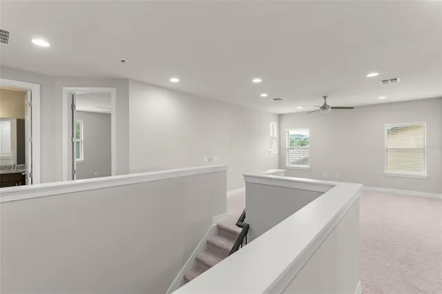 a view of a kitchen with a sink and dishwasher a refrigerator with white cabinets