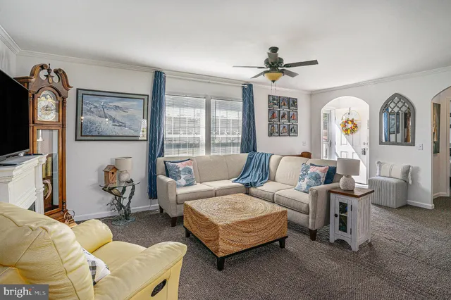 a living room with furniture two windows and a flat screen tv