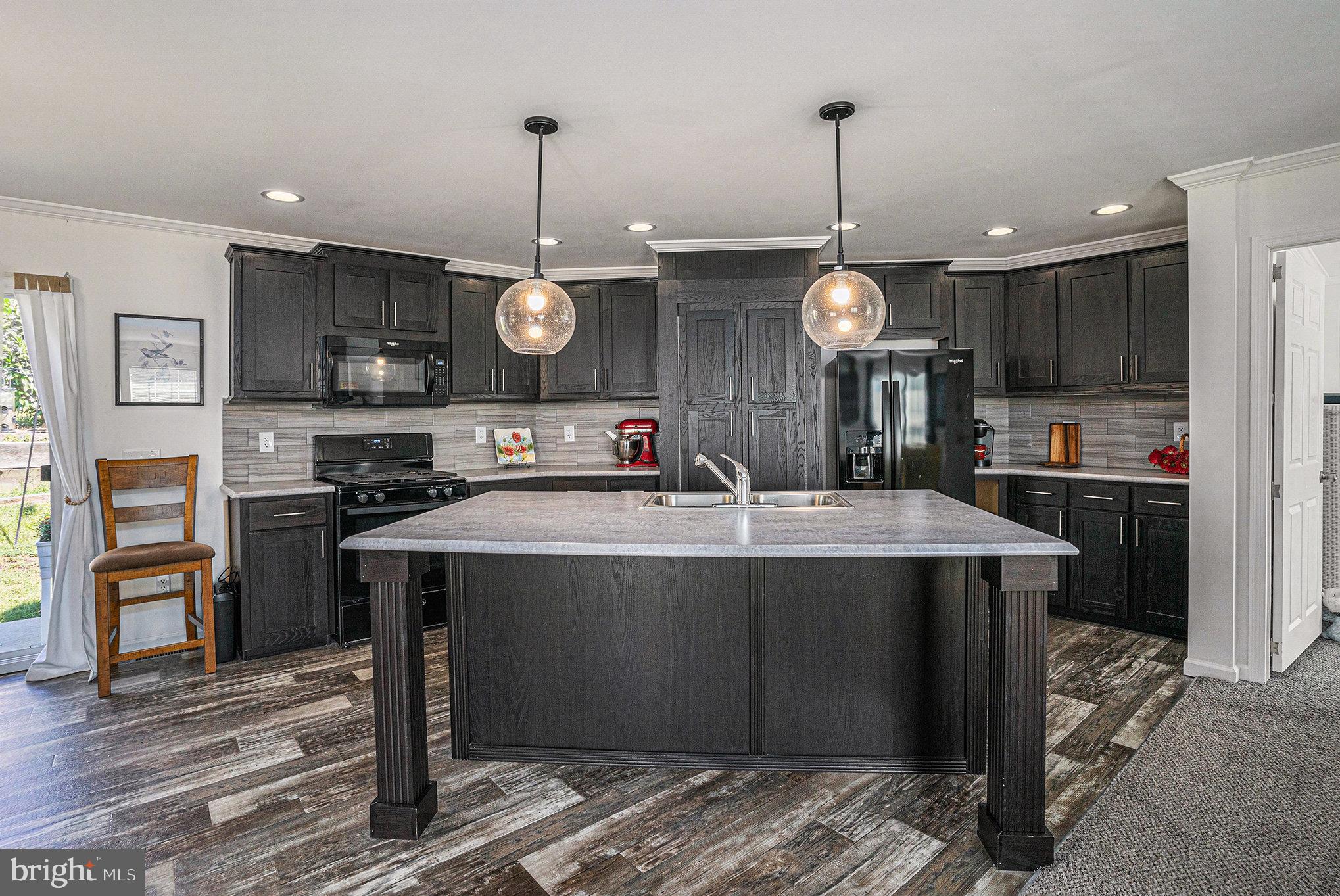 906 Lakeview Drive Green Lane, PA 18054 - Photo 9 of 37 a kitchen with stainless steel appliances granite countertop a sink a stove and a wooden floors