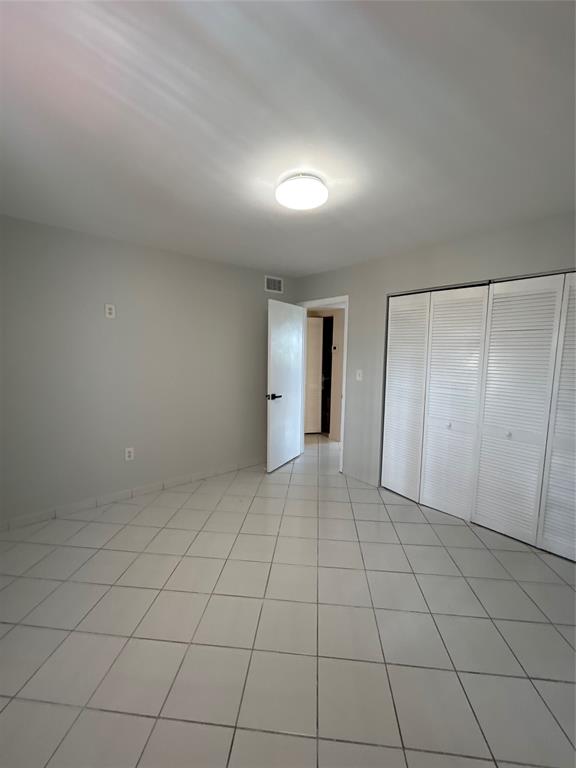 1855 West 60th Street, Unit 325 Hialeah, FL 33012 - Photo 8 of 18 an empty room with white walls and tiles