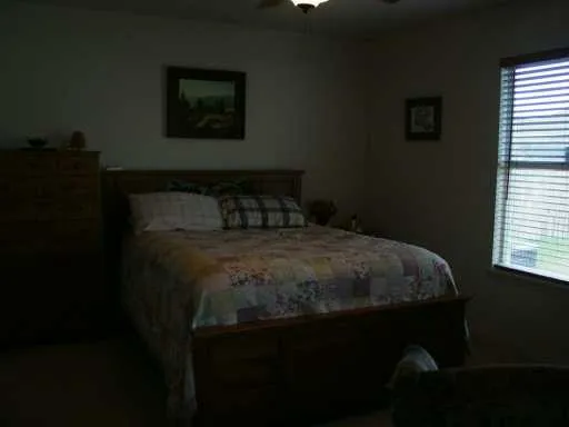a bed sitting in a bedroom next to a window