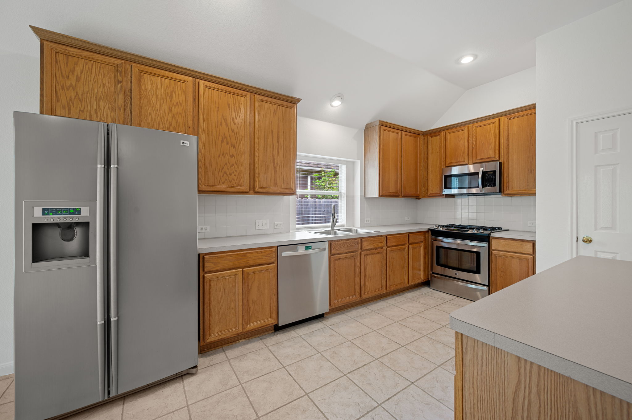 9201 La Siesta Bend Austin, TX 78749 - Photo 14 of 37 a kitchen with stainless steel appliances granite countertop a refrigerator stove top oven and sink
