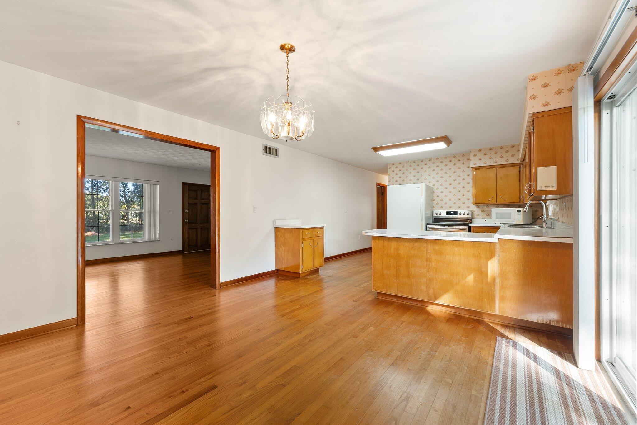 11541 Okeechobee Road Fort Pierce, FL 34945 - Photo 16 of 46 a view of kitchen and dining room with wooden floor