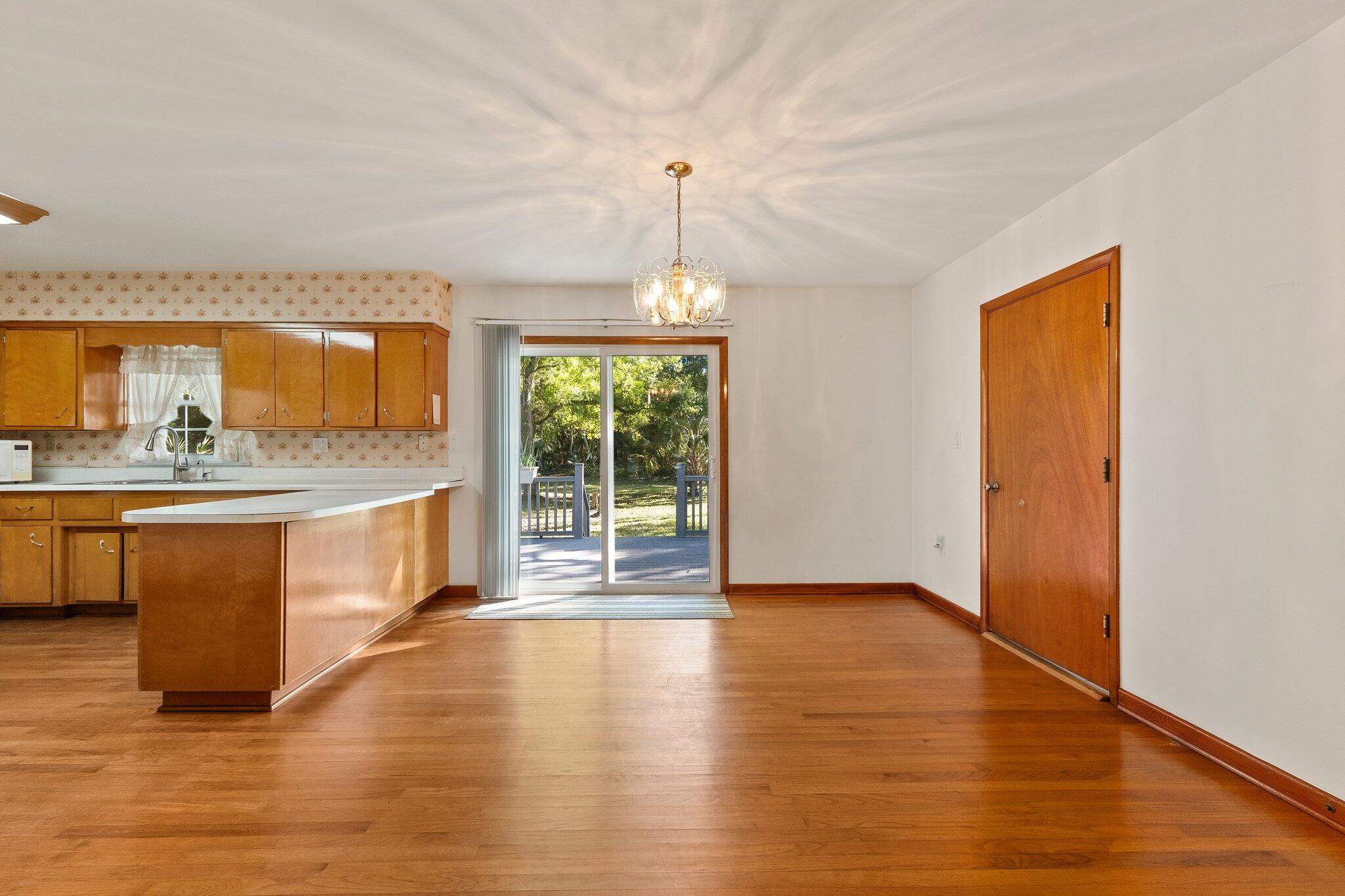 11541 Okeechobee Road Fort Pierce, FL 34945 - Photo 17 of 46 a view of a kitchen with kitchen island a sink wooden floor and a large window