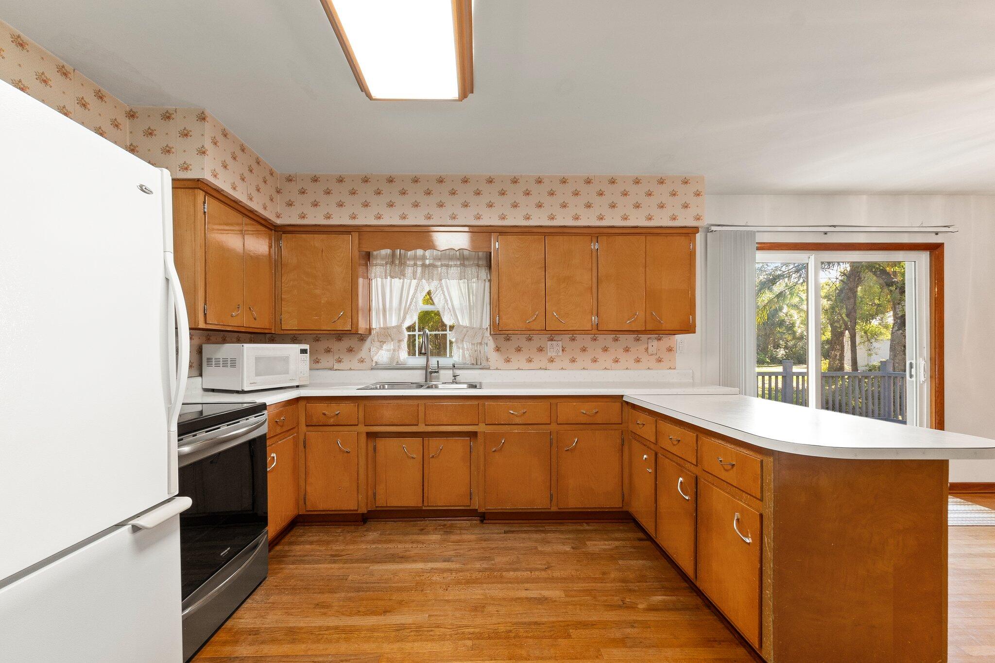 11541 Okeechobee Road Fort Pierce, FL 34945 - Photo 19 of 46 a large kitchen with a sink and cabinets