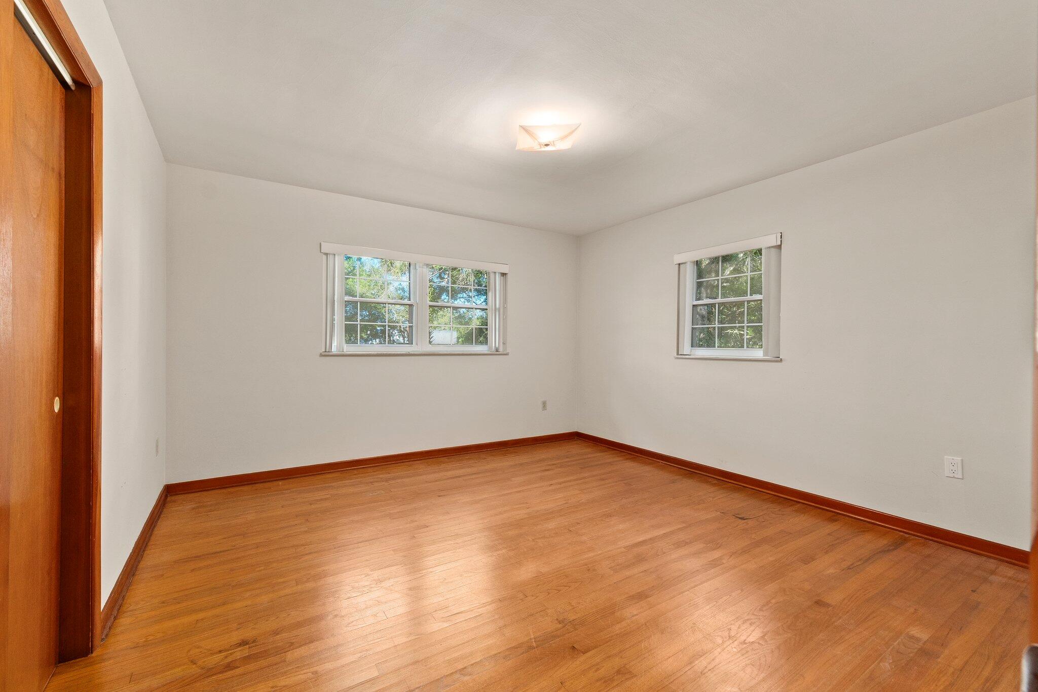 11541 Okeechobee Road Fort Pierce, FL 34945 - Photo 21 of 46 a view of an empty room with wooden floor and a window