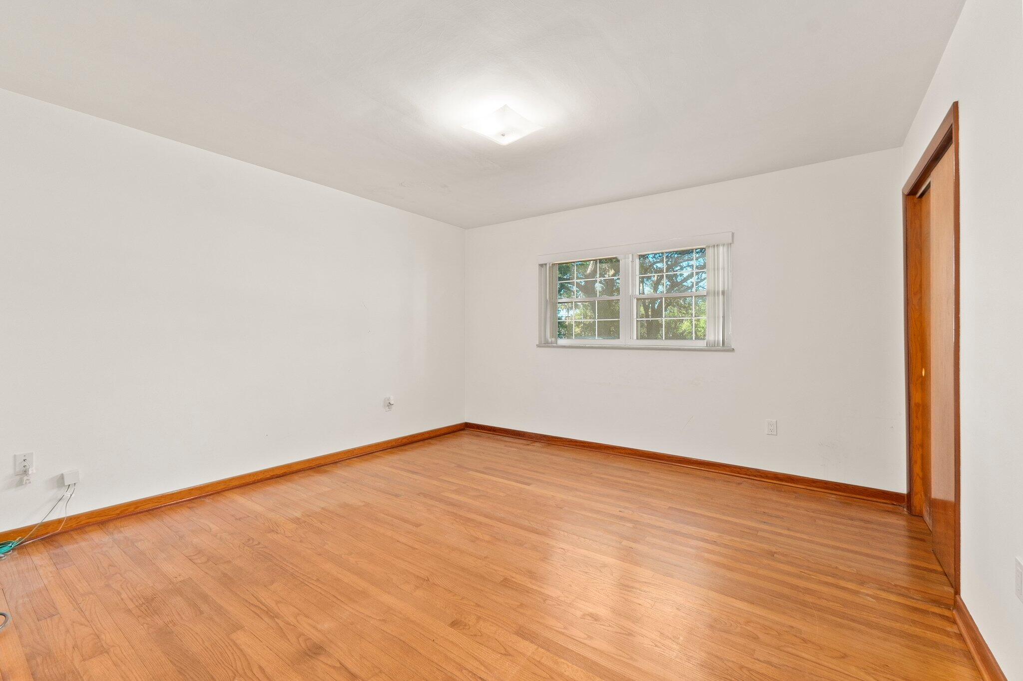 11541 Okeechobee Road Fort Pierce, FL 34945 - Photo 22 of 46 an empty room with wooden floor and windows