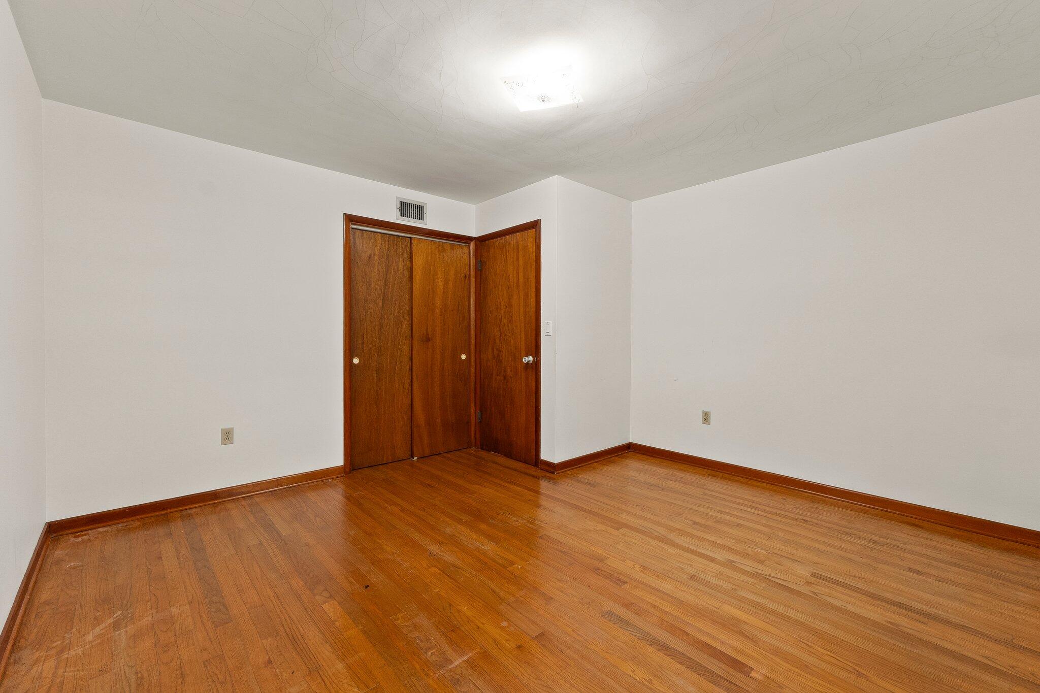 11541 Okeechobee Road Fort Pierce, FL 34945 - Photo 23 of 46 an empty room with wooden floor and windows