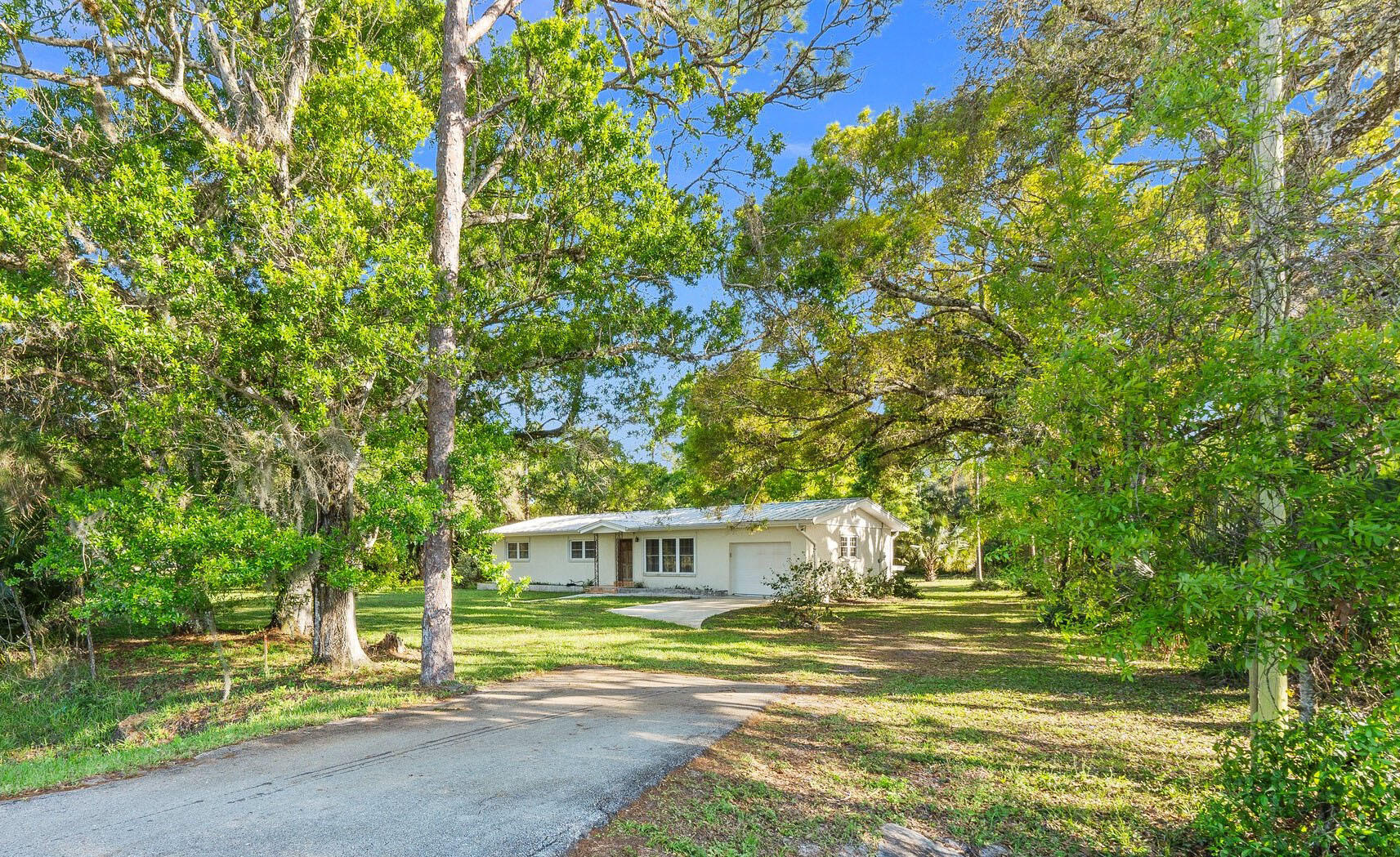 11541 Okeechobee Road Fort Pierce, FL 34945 - Photo 3 of 46 a view of a house with a large tree and a yard