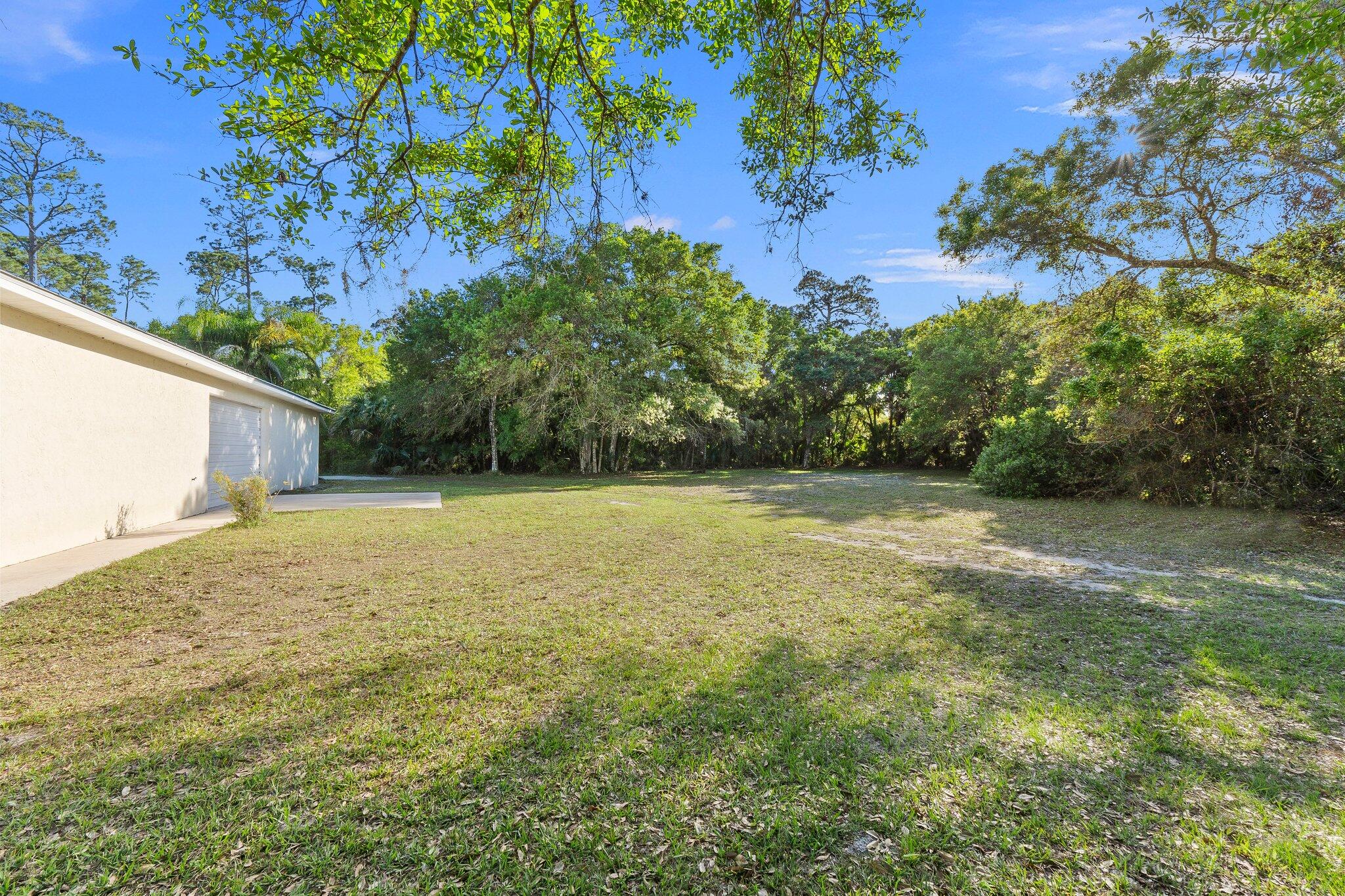 11541 Okeechobee Road Fort Pierce, FL 34945 - Photo 31 of 46 a backyard of a house with lots of green space