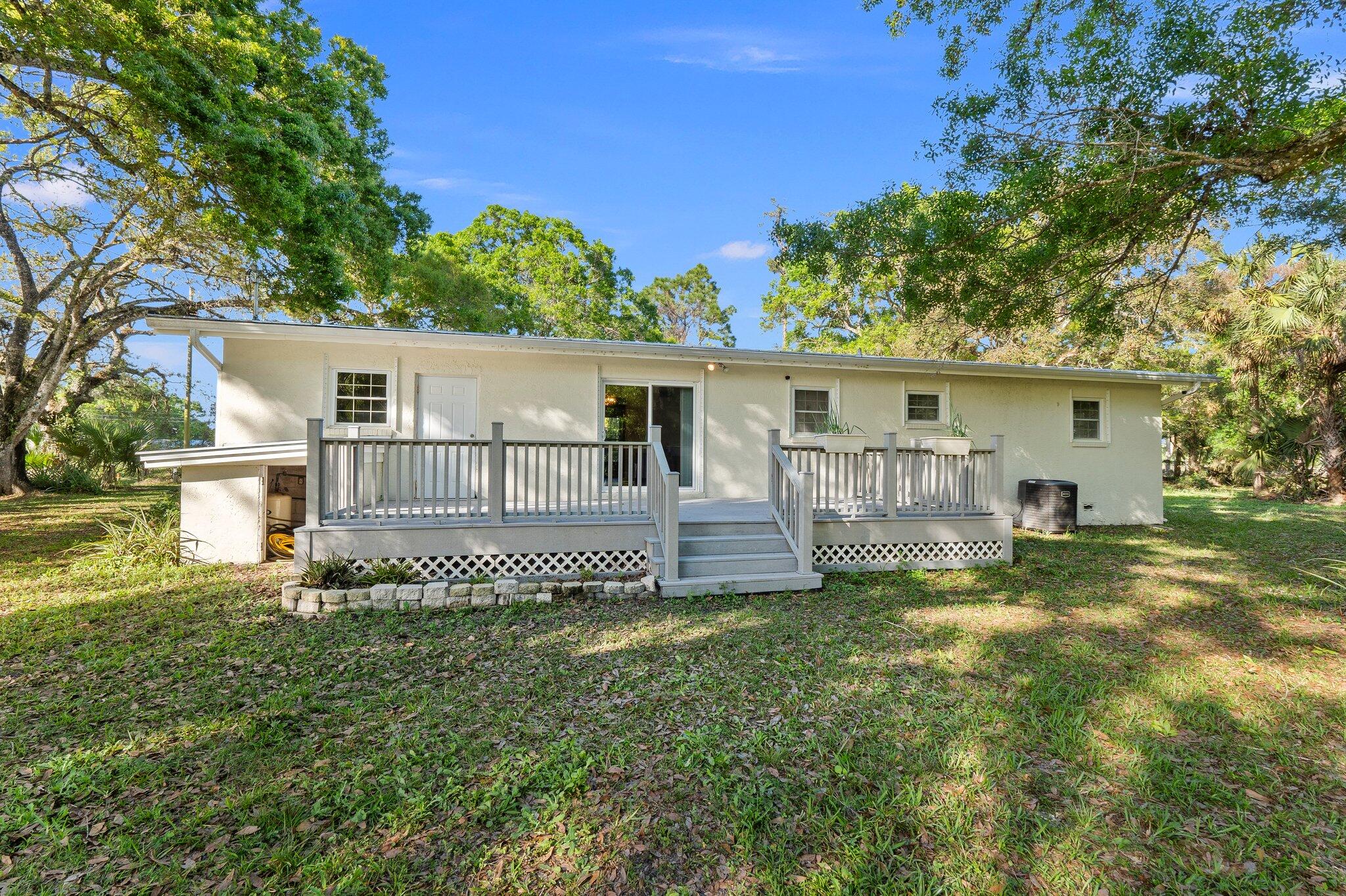 11541 Okeechobee Road Fort Pierce, FL 34945 - Photo 7 of 46 a front view of a house with a yard table and chairs