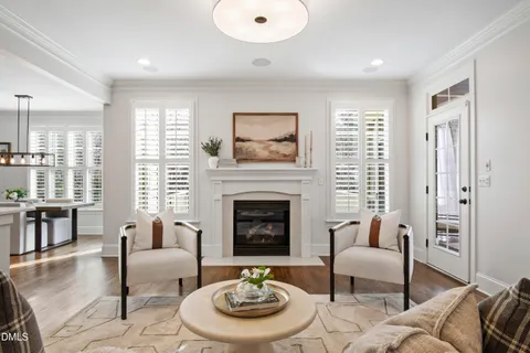 a living room with furniture kitchen view and a wooden floor