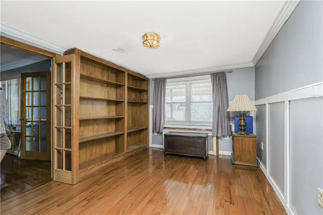 a view of living room with wooden floor and electronic appliances