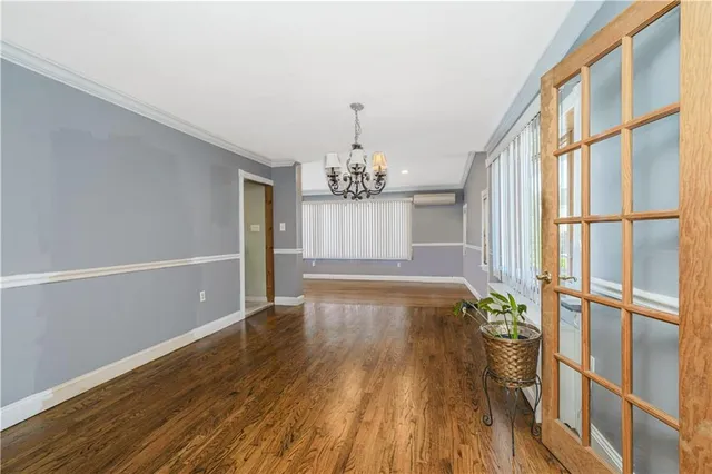 a view of a room with wooden floor and chandelier