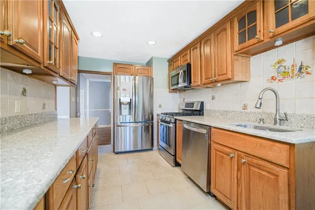 a kitchen with stainless steel appliances granite countertop a sink stove and refrigerator