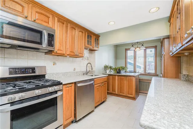 a kitchen with stainless steel appliances granite countertop a stove microwave and sink