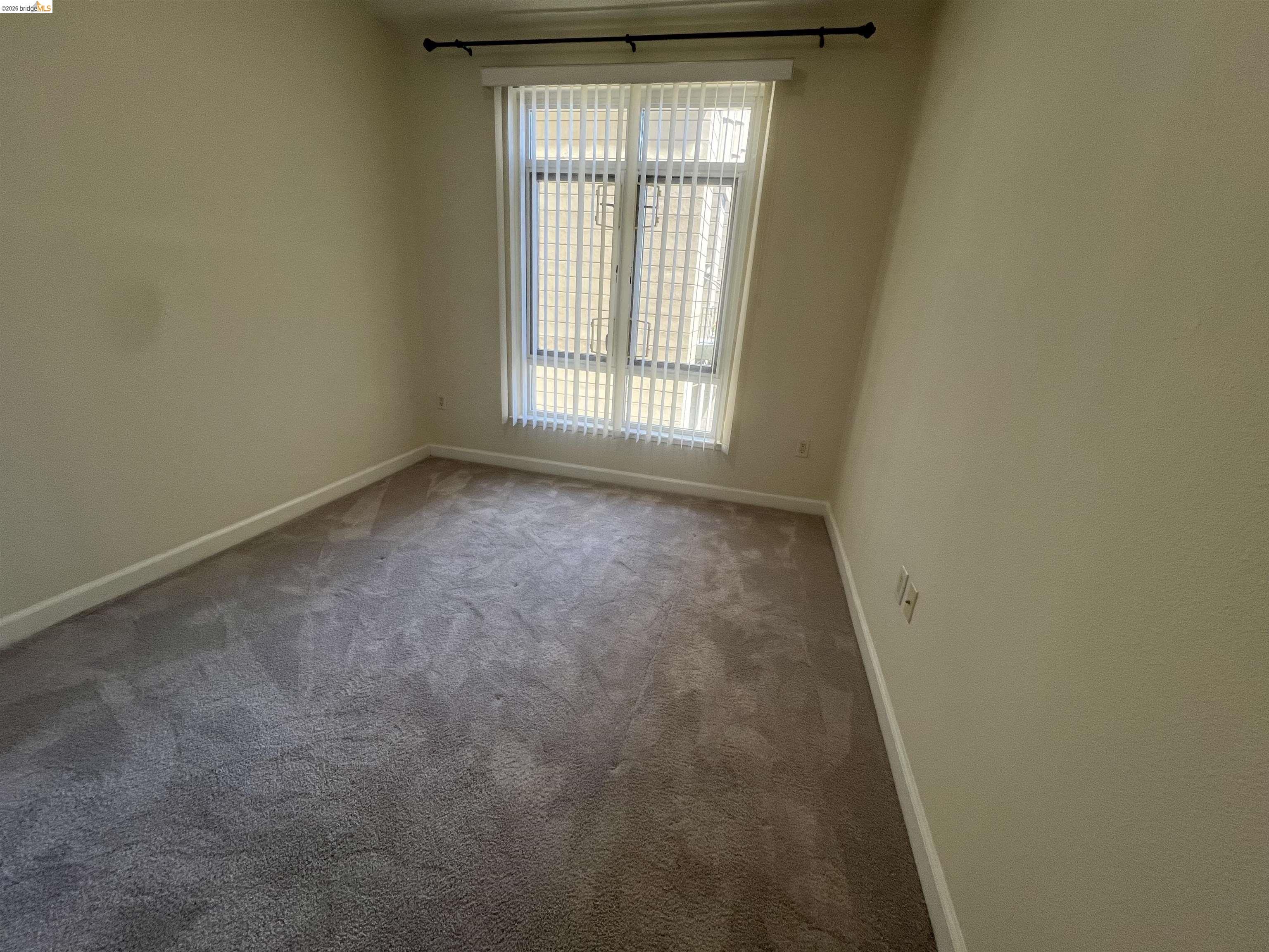 423 7th Street, Unit 313 Oakland, CA 94607 - Photo 6 of 11 Neutral-toned carpeting paired with light-colored walls