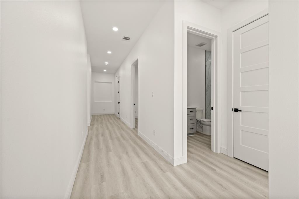 3323 Reed Lane Dallas, TX 75215 - Photo 25 of 33 a view of a hallway with wooden floor and a bathroom