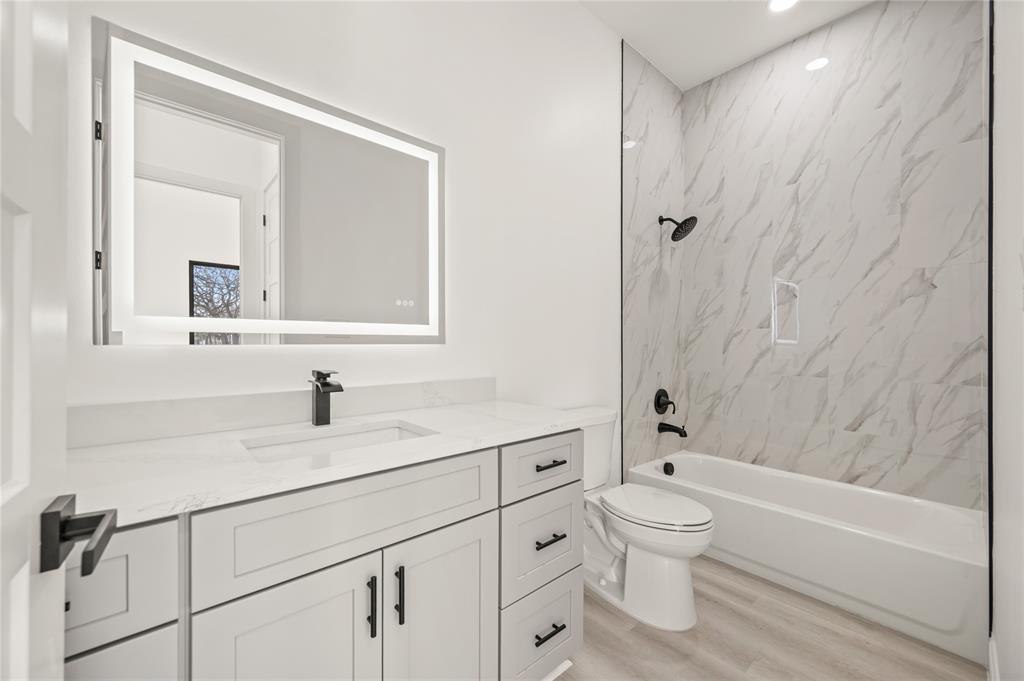 3323 Reed Lane Dallas, TX 75215 - Photo 27 of 33 a bathroom with a granite countertop toilet a sink and a bathtub