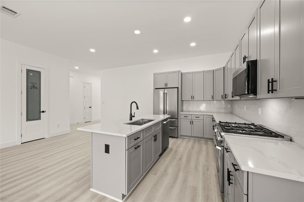3323 Reed Lane Dallas, TX 75215 - Photo 10 of 33 a kitchen with stainless steel appliances sink a microwave and cabinets