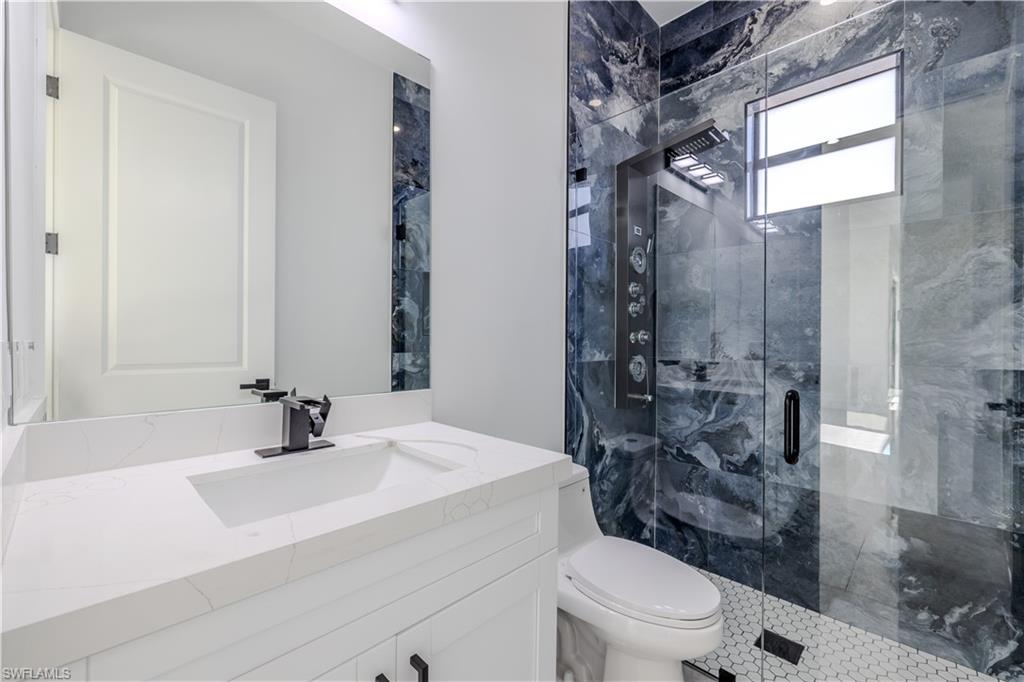 3303 24th Street Southwest Lehigh Acres, FL 33976 - Photo 13 of 25 a bathroom with a sink toilet vanity and shower