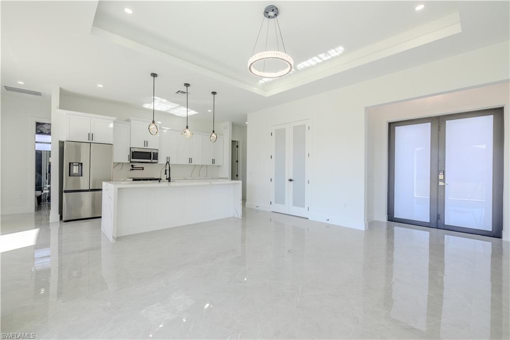 3303 24th Street Southwest Lehigh Acres, FL 33976 - Photo 5 of 25 a large white kitchen with cabinets and stainless steel appliances