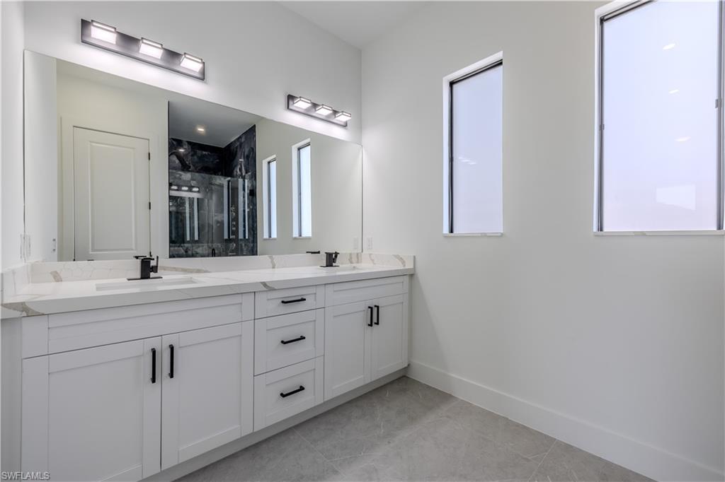 3303 24th Street Southwest Lehigh Acres, FL 33976 - Photo 10 of 25 a bathroom with double sink and a mirror